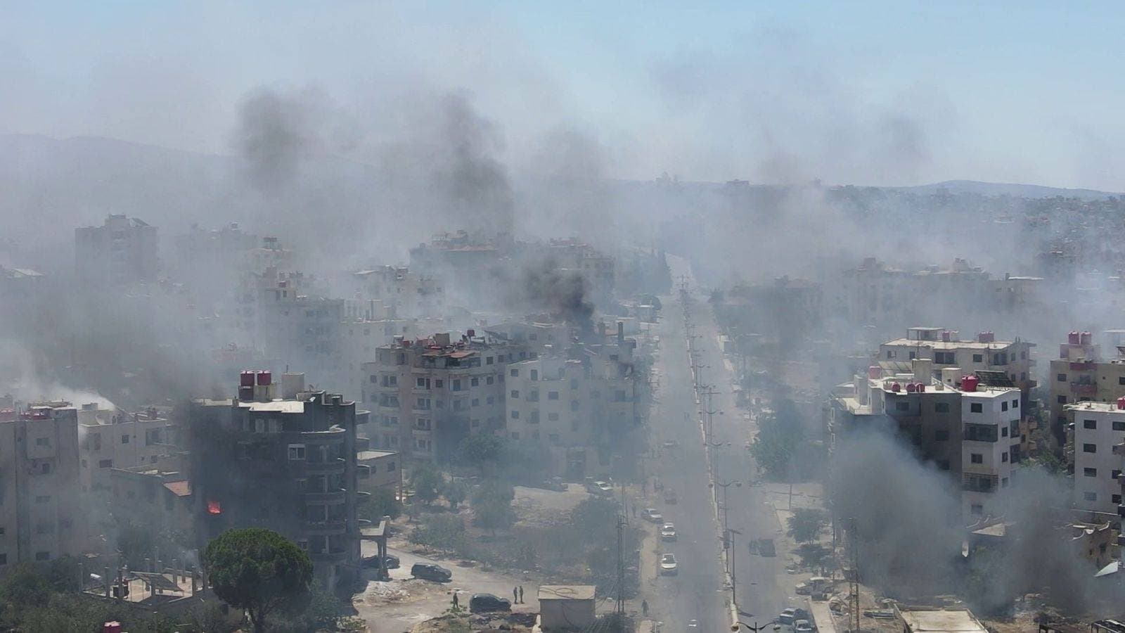 Homes still burning after mass pillaging and 30,000 trapped in besieged city as Syria's fragile ceasefire holds